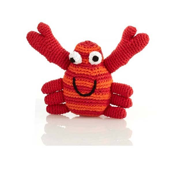 A red and orange striped crochet crab rattle with a smiling face and raised claws.
