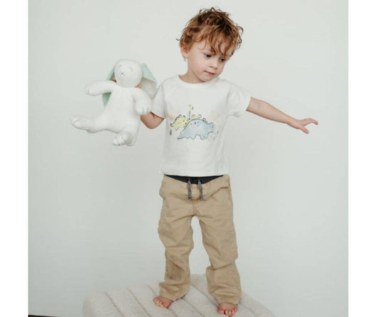 Child holding a stuffed animal with a plain background
