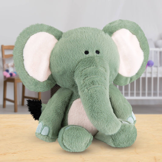 Green plush elephant toy on a wooden surface with a blurred background