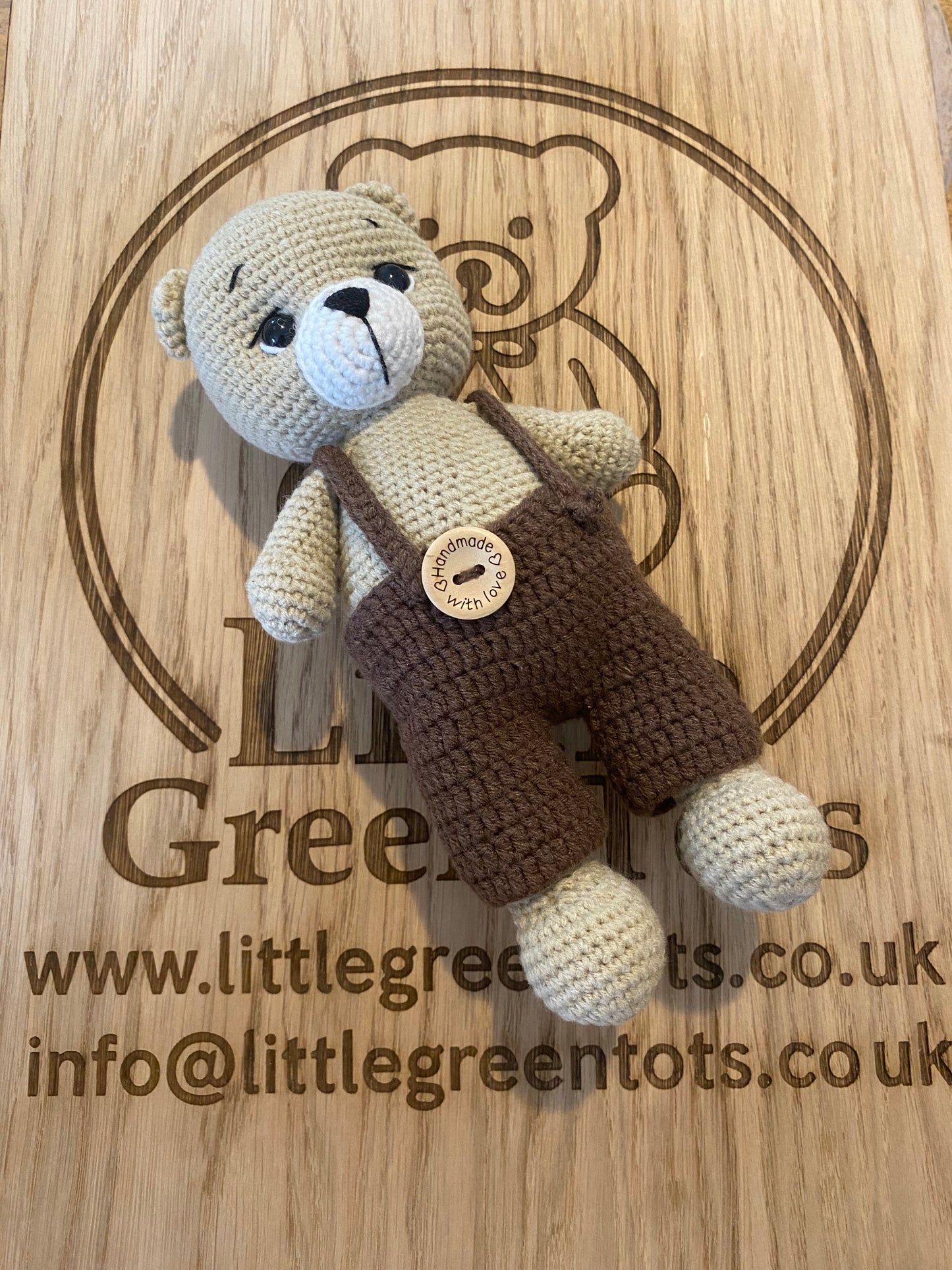Brown teddy bear laying on wooden board