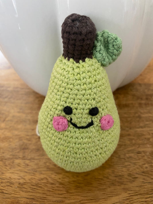 Crocheted pear-shaped toy on a wooden surface