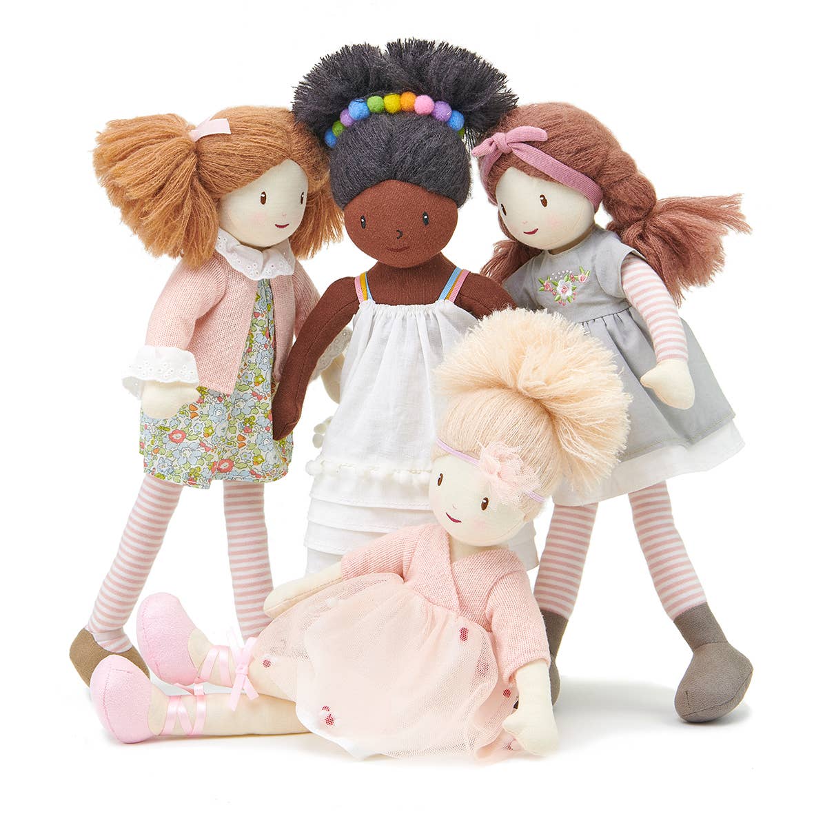 Four dolls with different hairstyles and outfits on a white background
