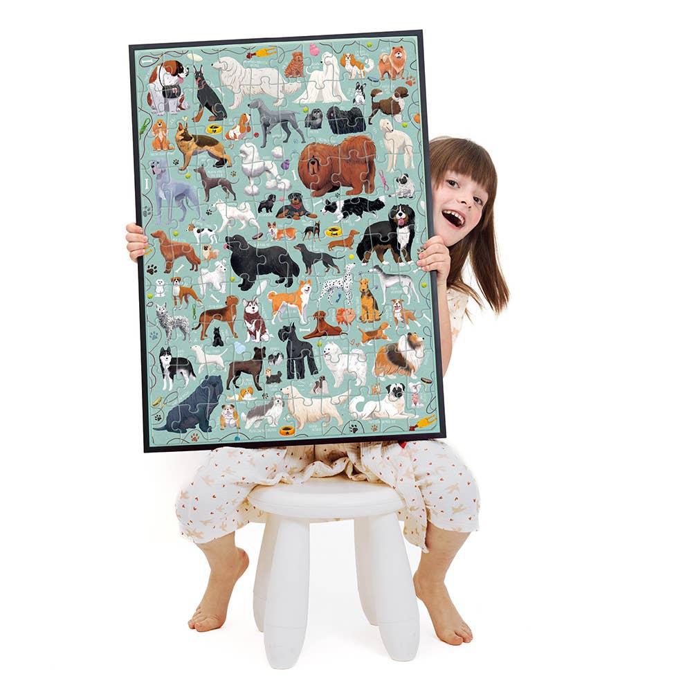 Child holding a large poster of dog breeds against a white background