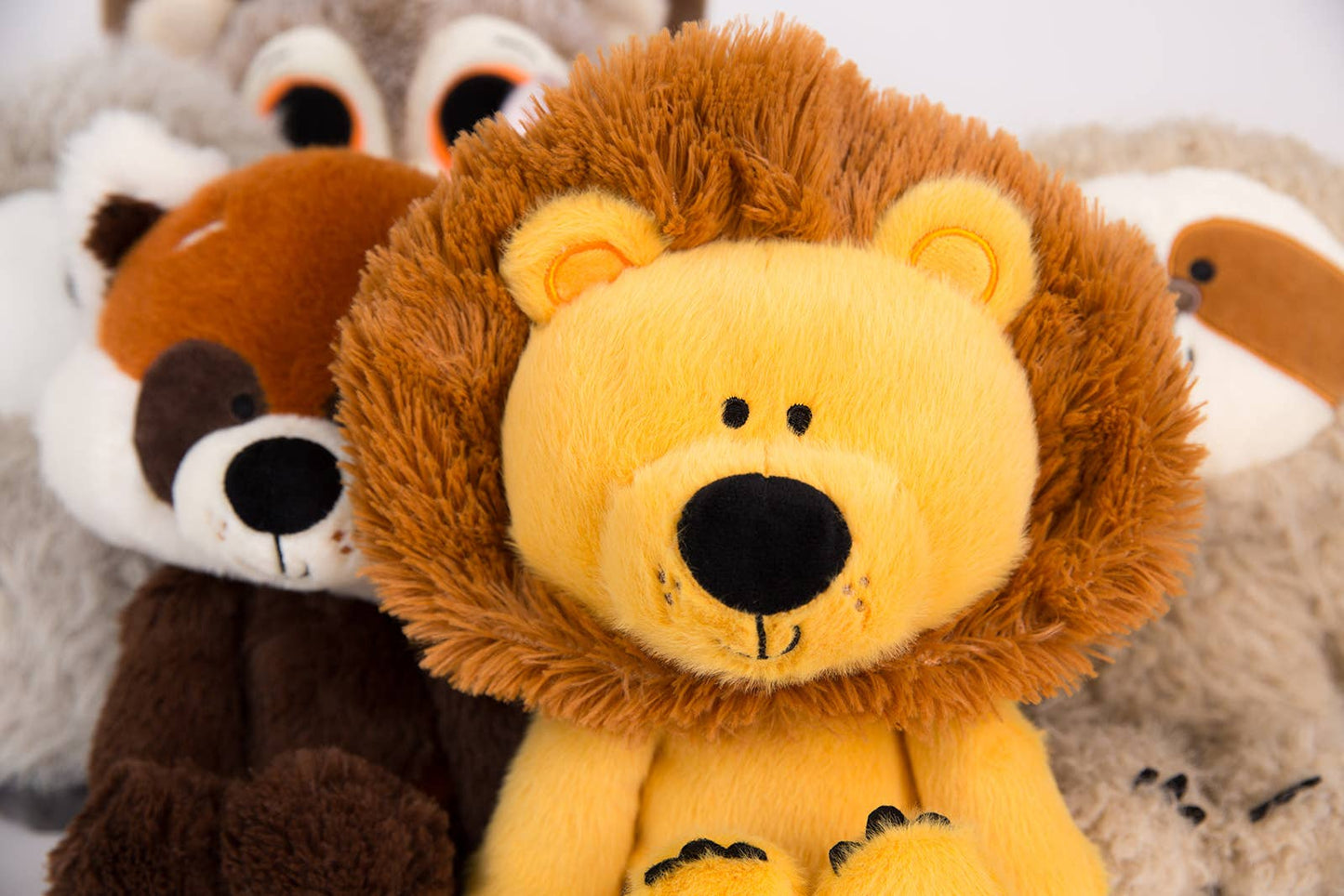 Close-up of a plush lion toy with other stuffed animals in the background