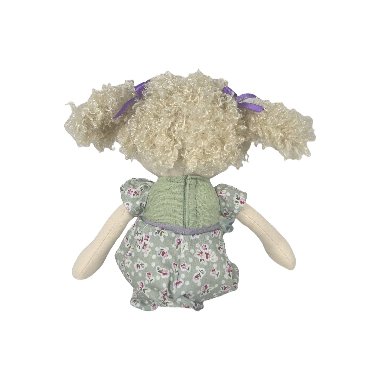 Stuffed doll with curly hair and a floral dress on a white background