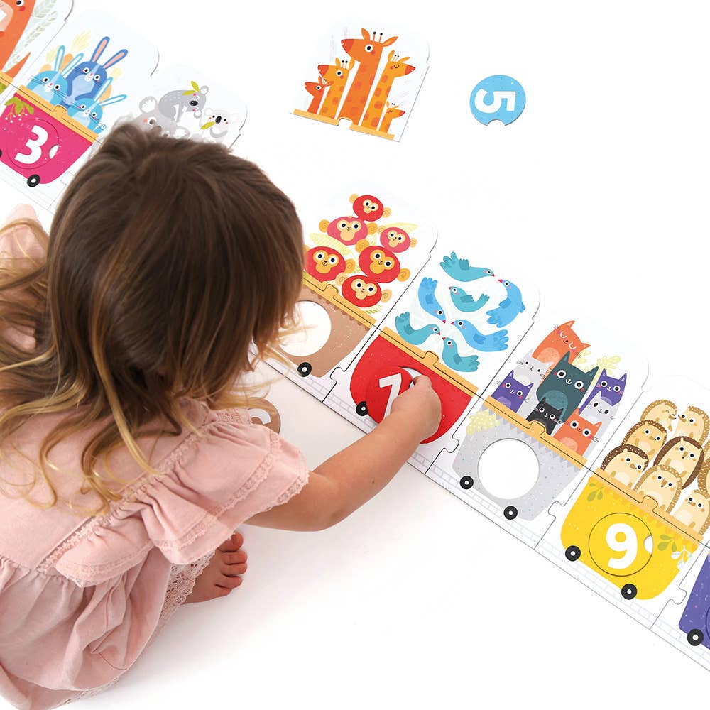 Child playing with a educational puzzle featuring animals and numbers.