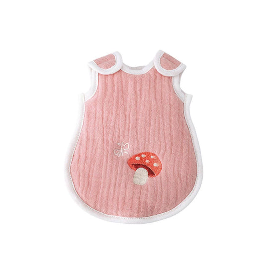 Pink baby bib with white trim and mushroom design on a white background
