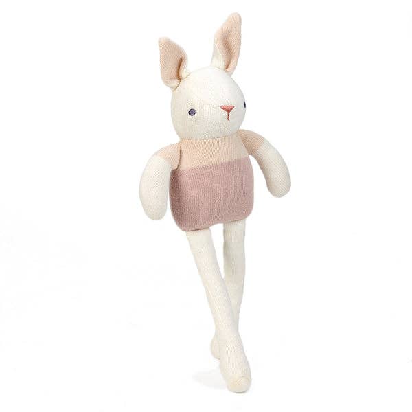 Stuffed animal rabbit wearing a pink sweater on a white background