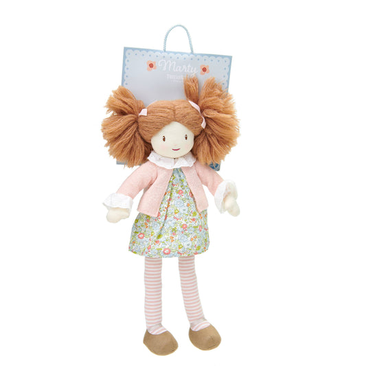 Stuffed doll with brown hair, floral dress, and pink coat on a white background
