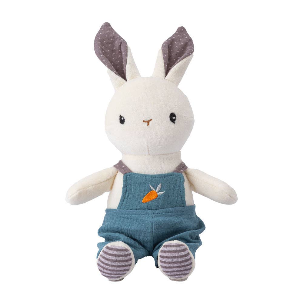 Plush toy rabbit wearing blue overalls on a white background