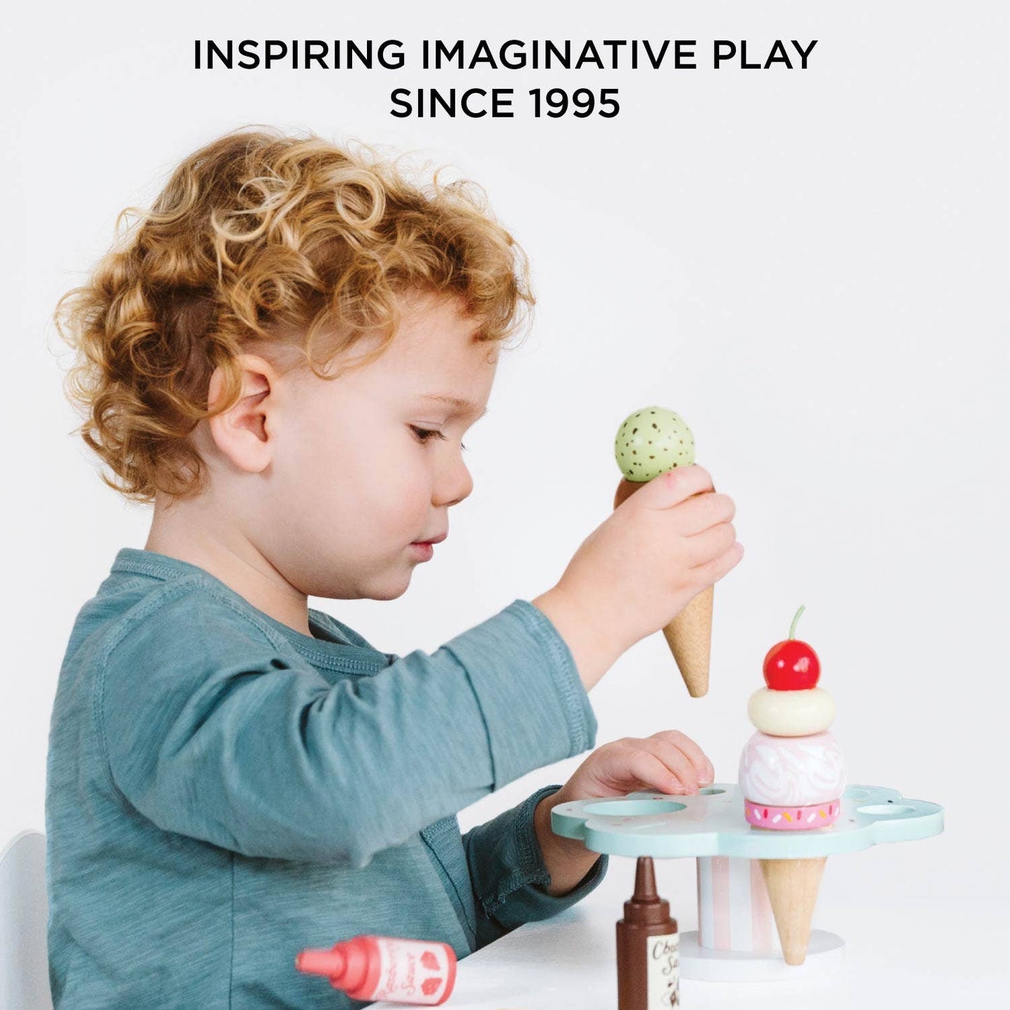Child playing with ice cream toys on a white background with text 'Inspiring Imaginative Play Since 1995'.
