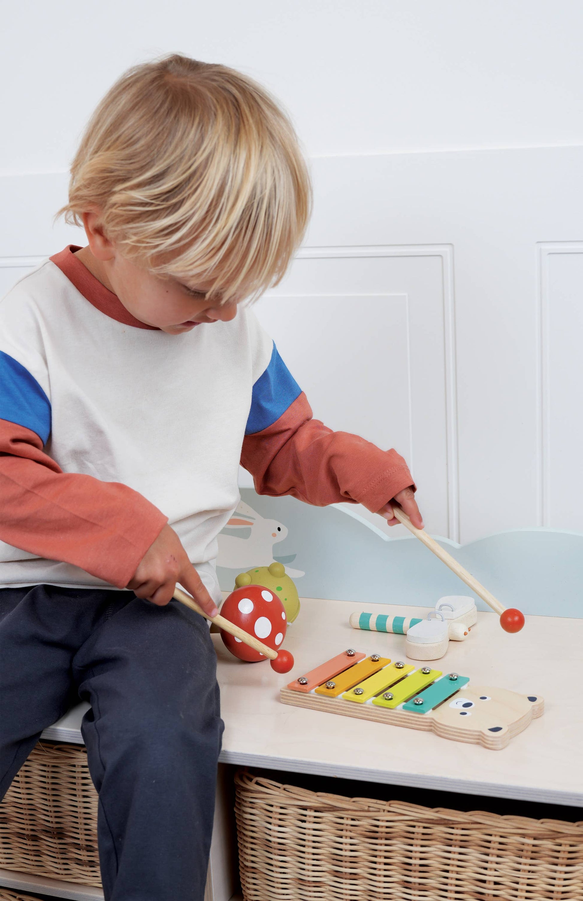 Child playing with toys on a table against a white wall