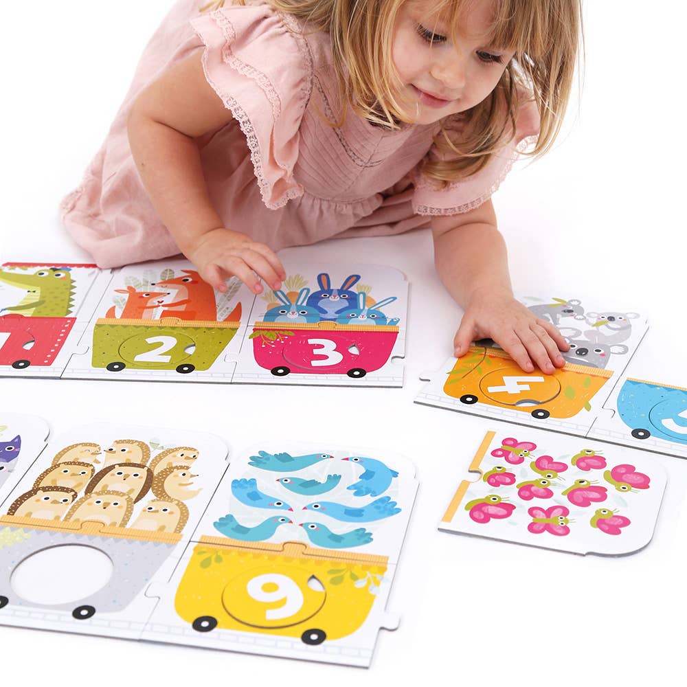 Child playing with educational puzzle cards featuring numbers and animals on a white background