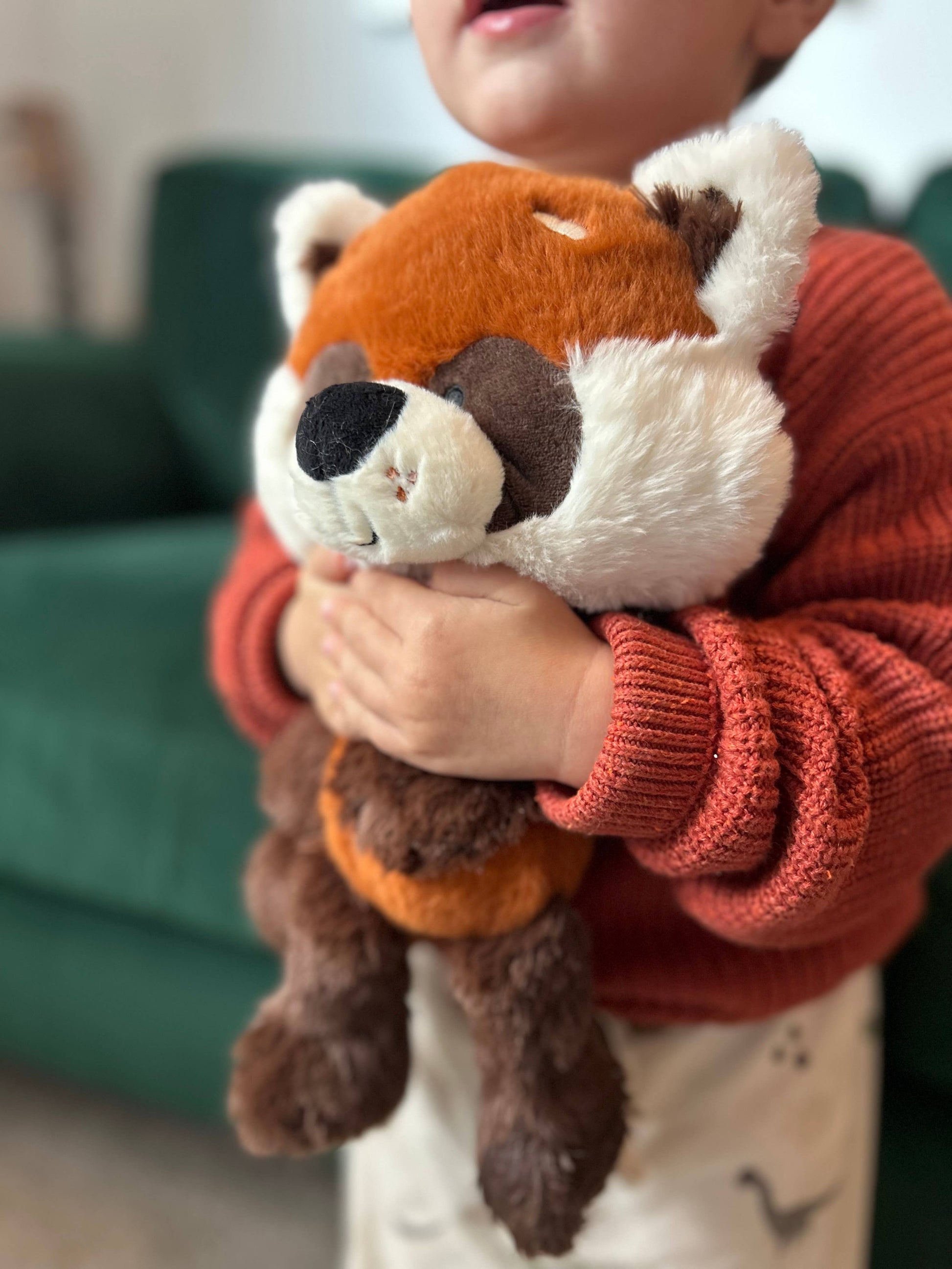 Child holding a plush toy in a cozy indoor setting