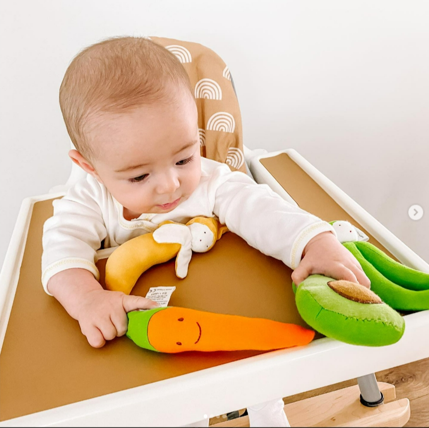 Baby playing with colorful toys on a high chair