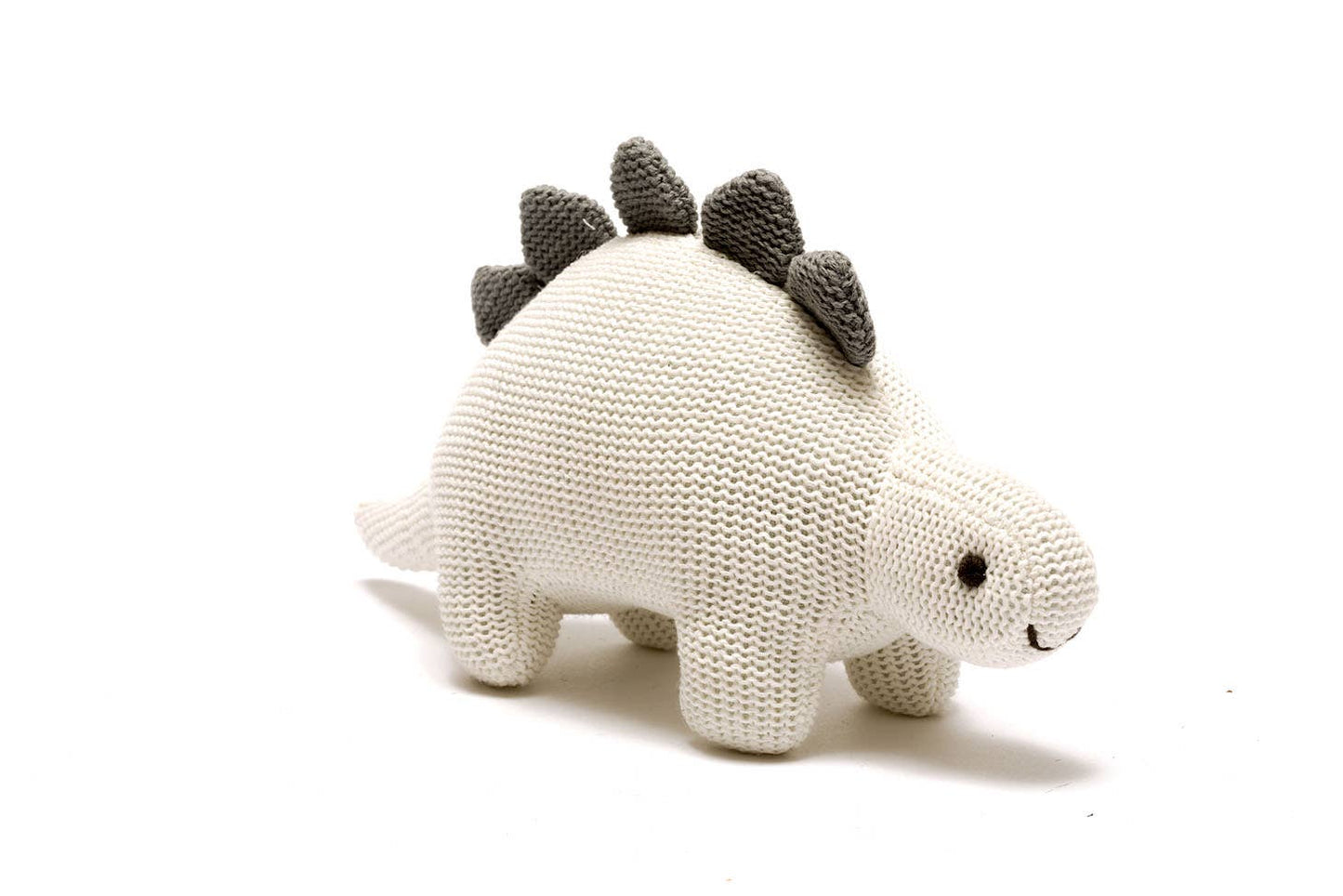 A white cotton knit Stegosaurus dinosaur rattle with black spiky details on its back.