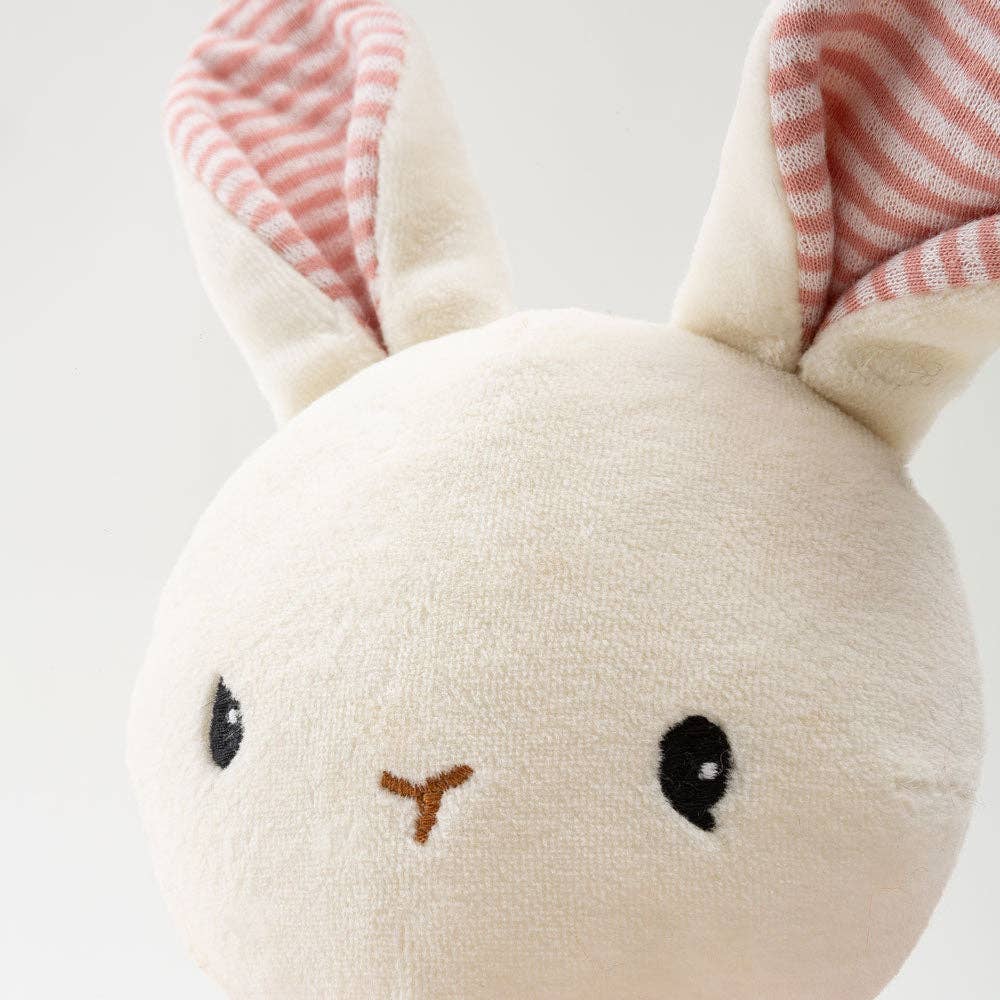 Small plush toy with bunny ears on a light background