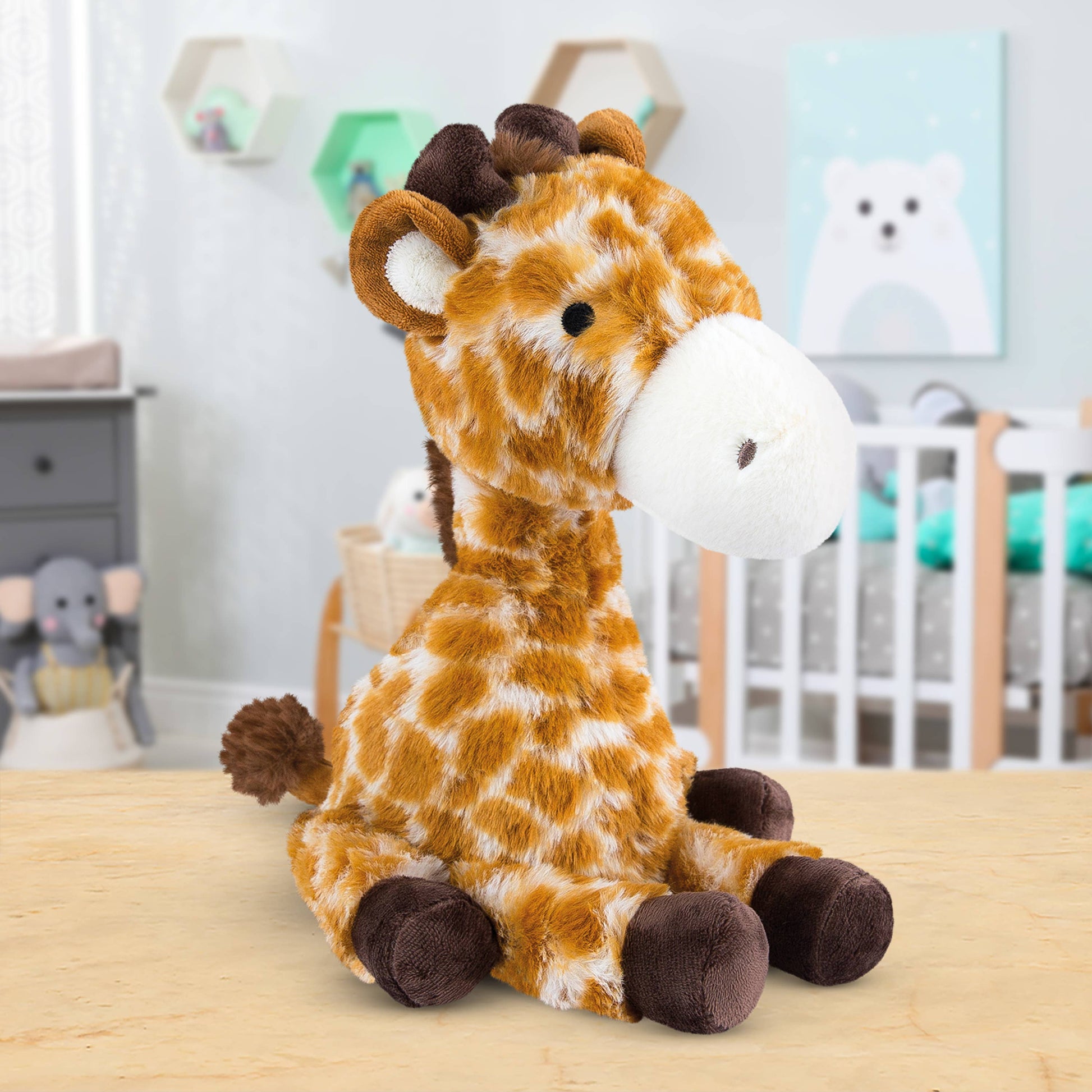 Plush giraffe toy on a wooden surface with a nursery in the background