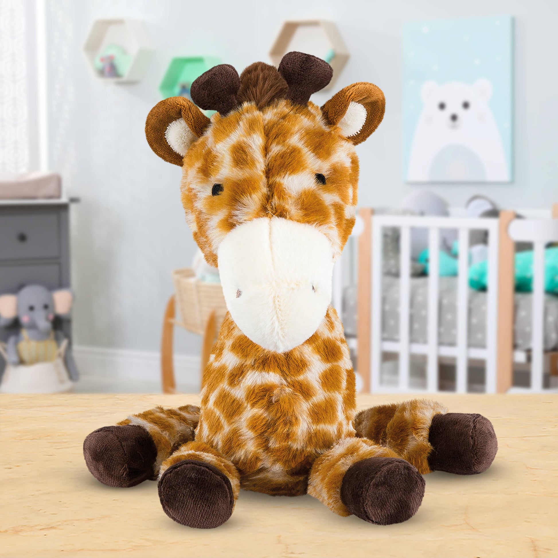 Plush giraffe toy on a wooden surface with a nursery in the background
