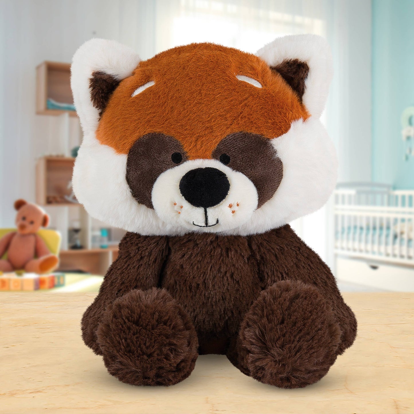 Plush toy red panda on a wooden surface with a blurred indoor background