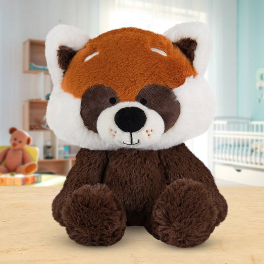 Plush toy red panda on a wooden surface with a blurred indoor background