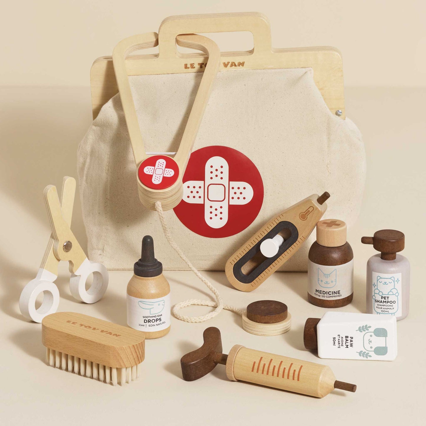 Set of wooden toys resembling medical supplies and a bag with a bandage design on a beige background.