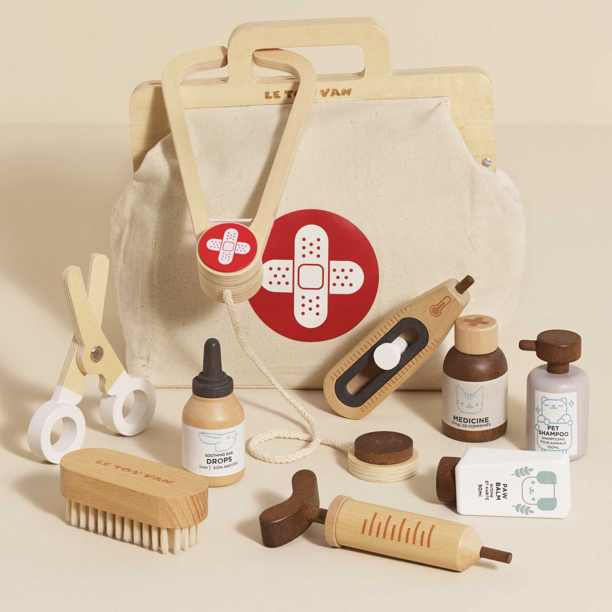 Set of wooden toys resembling medical supplies and a bag with a bandage design on a beige background.