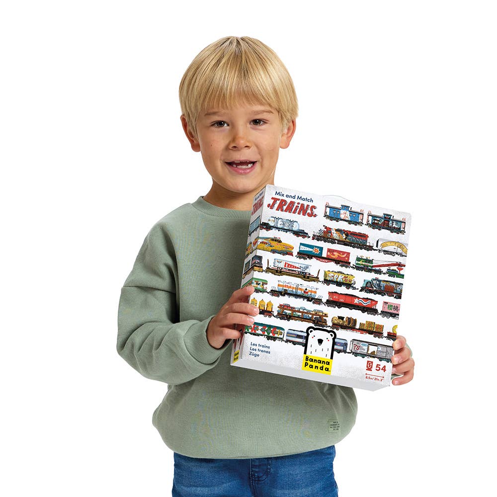 Child holding a toy train set packaging with various train models on a white background