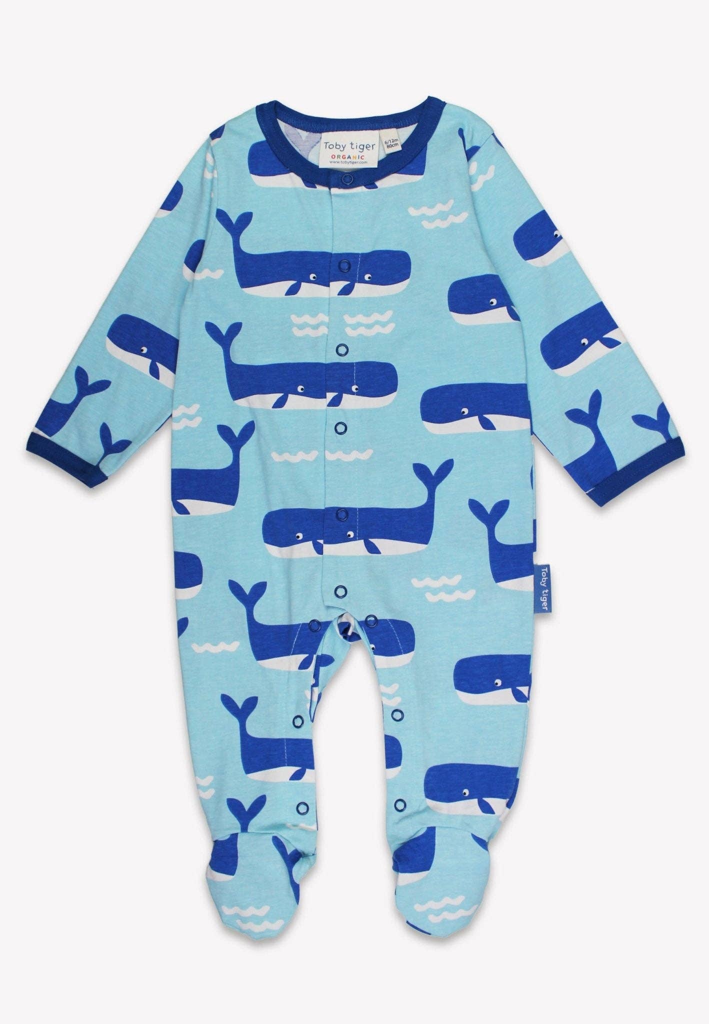 Baby onesie with whale pattern on a light blue background