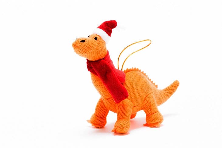 Orange dinosaur toy with a red scarf and Santa hat on a white background