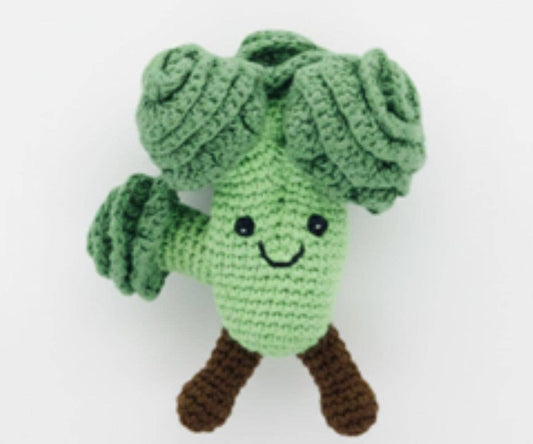 Crocheted green broccoli toy with a smiling face on a white background