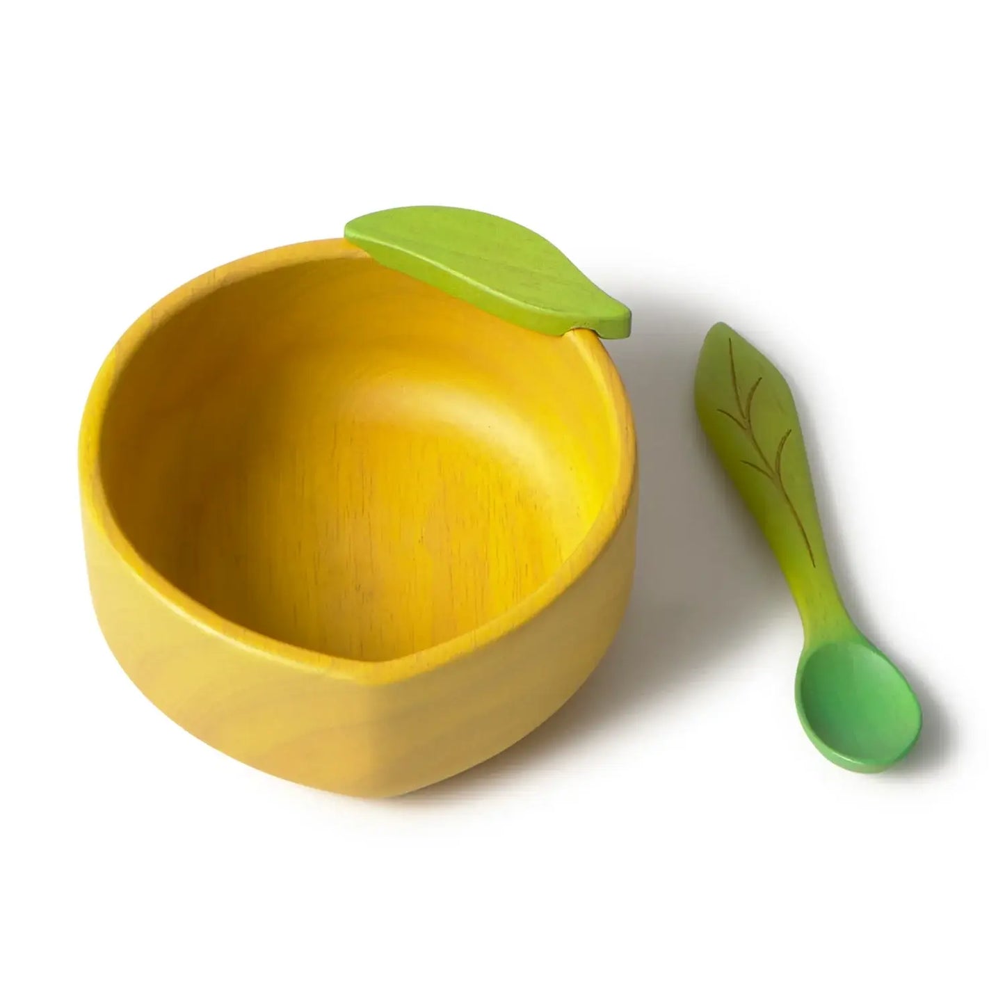 Yellow bowl and green spoon shaped like a lemon on a white background
