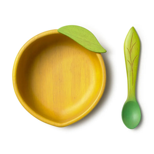 Yellow bowl with a green leaf and matching green spoon on a white background